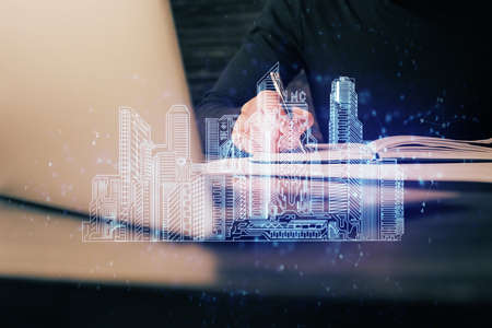 Abstract holographic city on mans hand writing notes background. Multi exposure.の写真素材