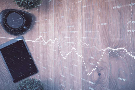 Multi exposure of financial chart hologram over desktop with phone. Top view. Mobile trade platform...