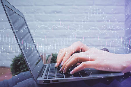 Multi exposure of woman hands typing on computer and forex chart hologram drawing. Stock market analysis concept.の写真素材