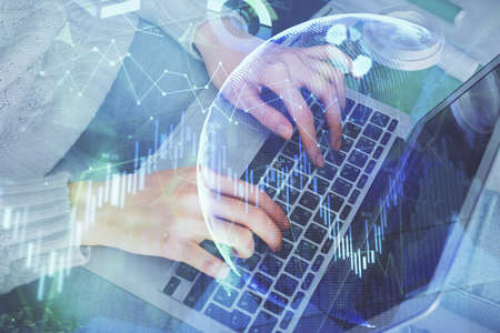 Double exposure of woman hands typing on computer and forex chart hologram drawing. Stock market...