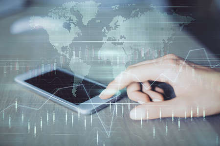 Double exposure of forex chart sketch hologram and woman holding and using a mobile device....