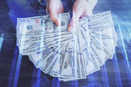 Multi exposure of financial graph drawing hologram and USA dollars bills and man hands. Analysis concept.の写真素材