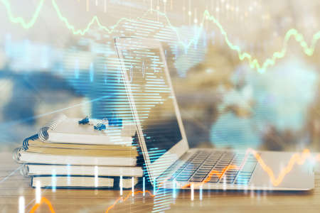 Stock market chart hologram drawn on personal computer background. Double exposure. Concept of...