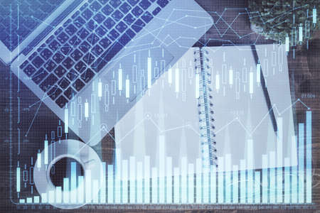 Financial market graph and top view computer on the desktop background. Double exposure. Investment...