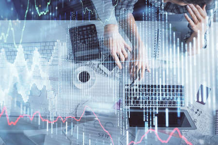 Double exposure of man and woman working together and financial graph hologram drawing. market...