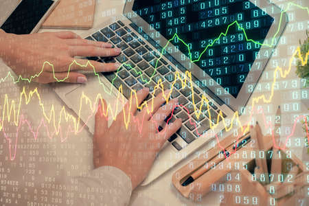 Double exposure of woman hands typing on computer and forex chart hologram drawing. Stock market...