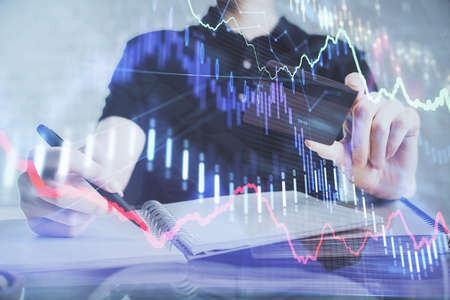 Double exposure of man hands holding a credit card and Forex graph drawing. Stock trading and...