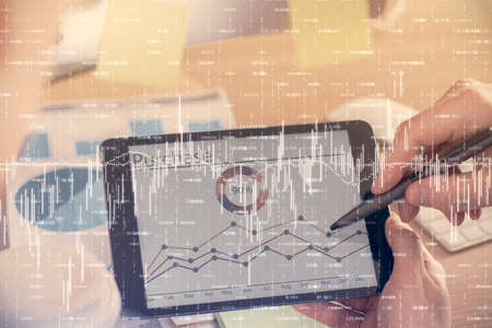Double exposure of mans hands holding and using a phone and financial chart drawing. Market analysis concept.の写真素材