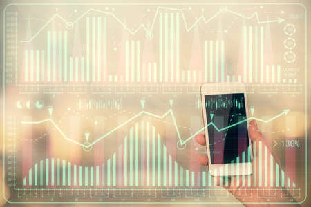 Double exposure of forex chart sketch hologram and woman holding and using a mobile device. Stock...