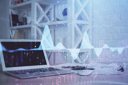 Stock market graph on background with desk and personal computer. Multi exposure. Concept of...