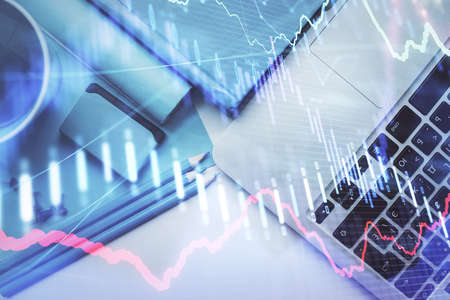 Double exposure of forex graph drawing over desktop background with computer. Concept of financial...