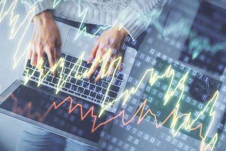 Multi exposure of woman hands working on computer and forex chart hologram drawing. Top View....