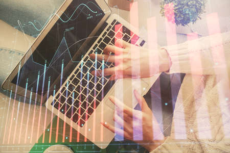 Double exposure of woman hands working on computer and forex chart hologram drawing. Top View....