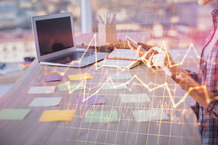 Double exposure of woman hands working on computer and forex graph hologram drawing. Financial analysis concept.の写真素材