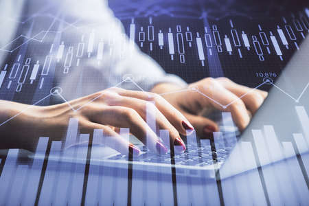 Double exposure of businesswoman hands typing on computer and forex chart hologram drawing....