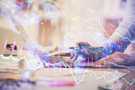 Double exposure of woman hands typing on computer and forex chart hologram drawing. Stock market...
