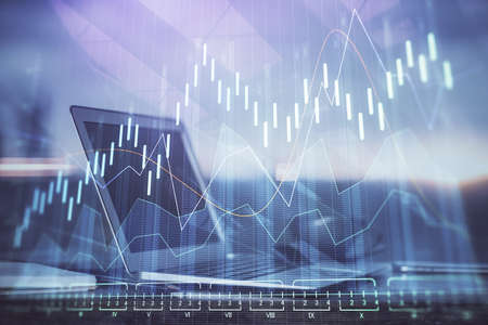 Stock market graph and table with computer background. Double exposure. Concept of financial...