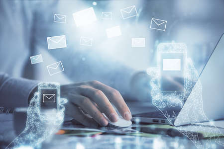 Envelop hologram drawing with businessman working on computer on background. Electronic mail concept. Double exposure.の写真素材