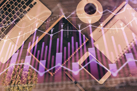 Double exposure of forex chart hologram over desktop with phone. Top view. Mobile trade platform...