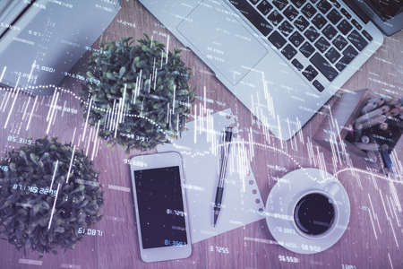Multi exposure of financial chart hologram over desktop with phone. Top view. Mobile trade platform...