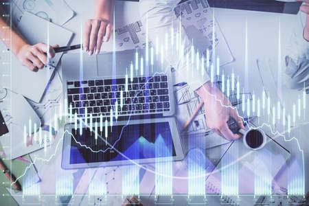 Double exposure of man and woman working together and financial graph hologram. Business concept....