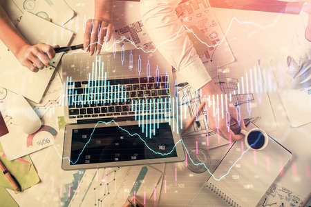 Double exposure of man and woman working together and financial graph hologram. Business concept....