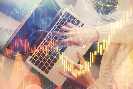 Double exposure of woman hands working on computer and forex chart hologram drawing. Top View....