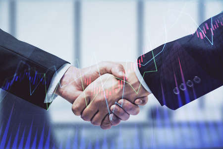 Double exposure of forex graph hologram and handshake of two men. Stock market concept.の写真素材