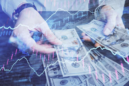 Multi exposure of financial graph drawing hologram and USA dollars bills and man hands. Analysis concept.の写真素材