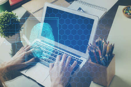 Fingerprint hologram with businessman working on computer on background. Security concept. Double...