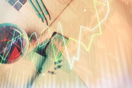 Double exposure of forex graph drawing over desktop background with computer. Concept of financial...