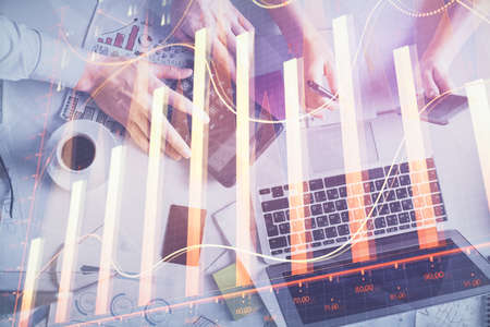 Double exposure of man and woman working together and financial chart hologram drawing. market...