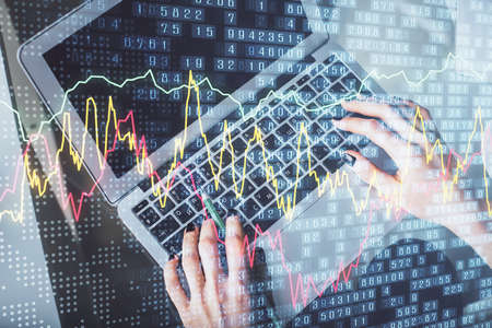 Double exposure of woman hands working on computer and forex chart hologram drawing. Top View....