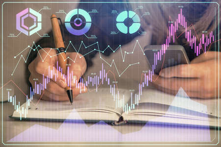 Double exposure of businesswoman hands typing on computer and forex graph hologram drawing....