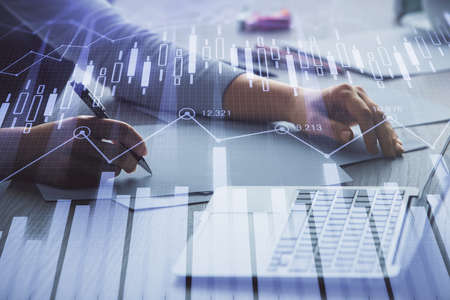Double exposure of businesswoman hands typing on computer and forex chart hologram drawing....