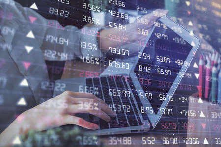 Double exposure of woman hands typing on computer and forex chart hologram drawing. Stock market...