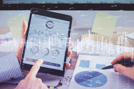 Multi exposure of mans hands holding and using a phone and financial chart drawing. Market analysis...