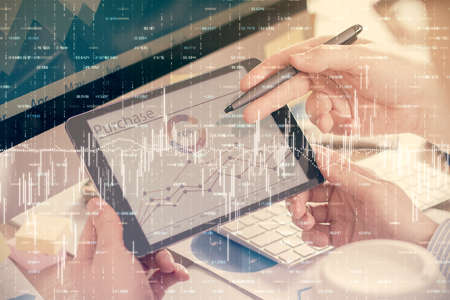 Double exposure of mans hands holding and using a phone and financial chart drawing. Market analysis...