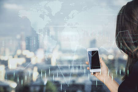 Double exposure of forex chart sketch hologram and woman holding and using a mobile device. Stock...