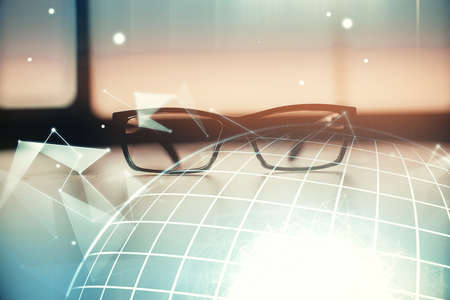 Map hologram with glasses on the table background. Concept of globalization. Double exposure.の写真素材