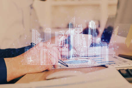 Abstract holographic city on mans hand writing notes background. Multi exposure.