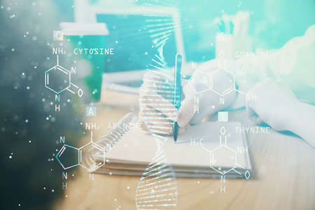 DNA theme hologram over womans hands writing background. Concept of education. Double exposureの写真素材