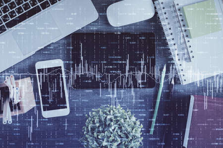 Double exposure of forex chart hologram over desktop with phone. Top view. Mobile trade platform concept.の写真素材