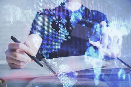 Double exposure of man hands holding a credit card and Forex graph drawing. Stock trading and digital fintech in Internet E-commerce concept.の写真素材