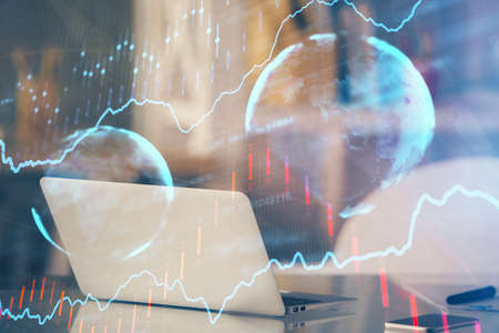 Stock market chart hologram drawn on personal computer background. Double exposure. Concept of...
