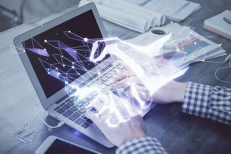 Handshake hologram drawing with businessman working on computer on background. Double exposure.