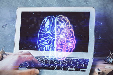 Businessman with computer background with brain theme hologram. Concept of brainstorm. Multi...