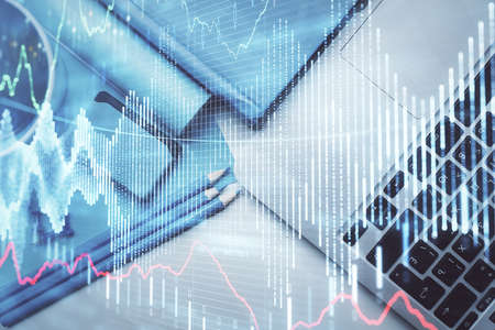 Double exposure of forex graph drawing over desktop background with computer. Concept of financial...