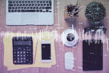 Double exposure of forex chart hologram over desktop with phone. Top view. Mobile trade platform concept.の写真素材