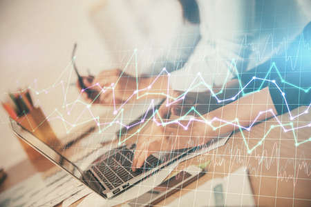 Multi exposure of woman hands typing on computer and financial chart hologram drawing. Stock market...